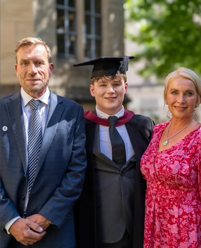 Graduate with his parents on graduation day